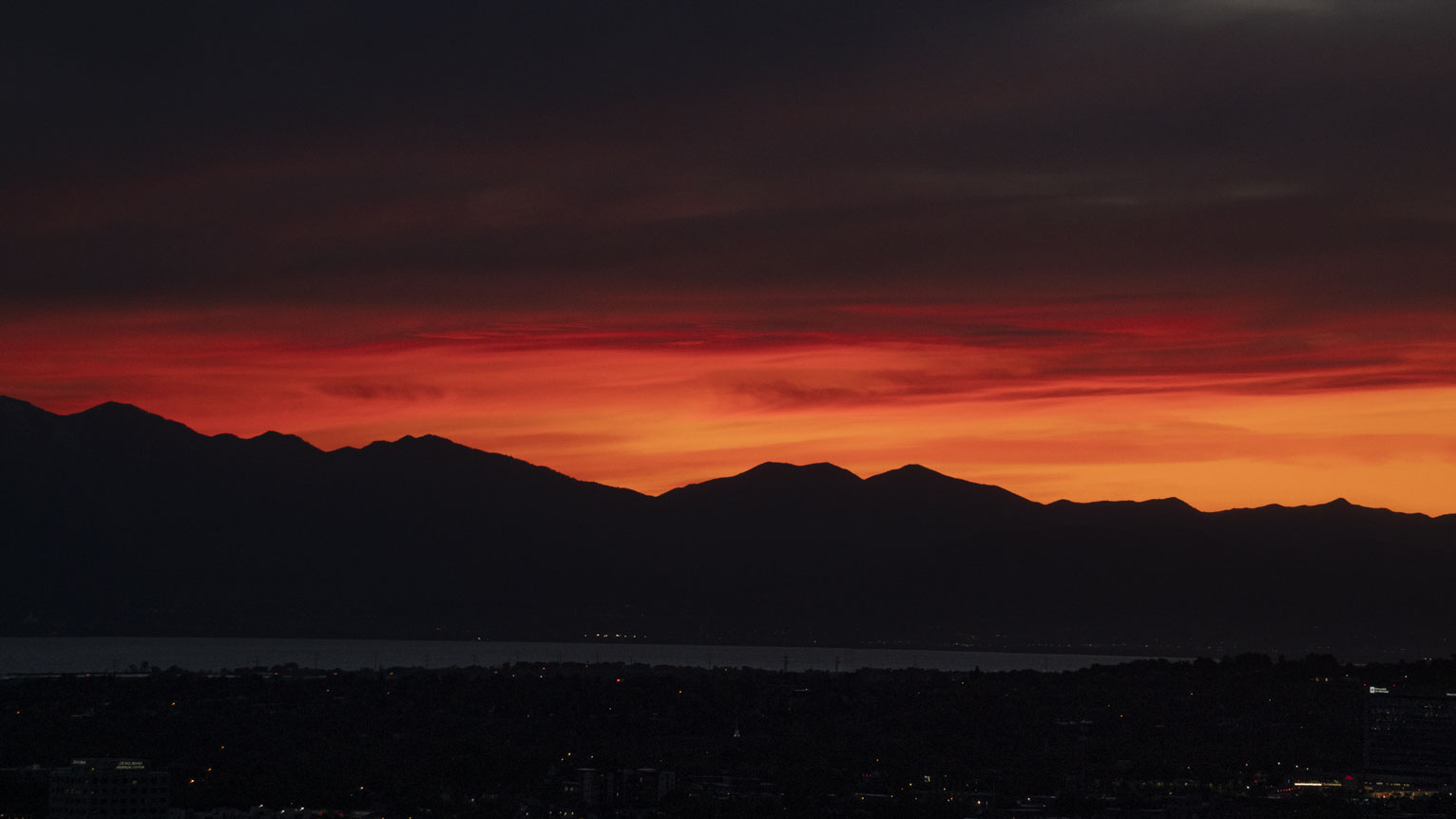 Sunset burns bright loopy reds above the mountains